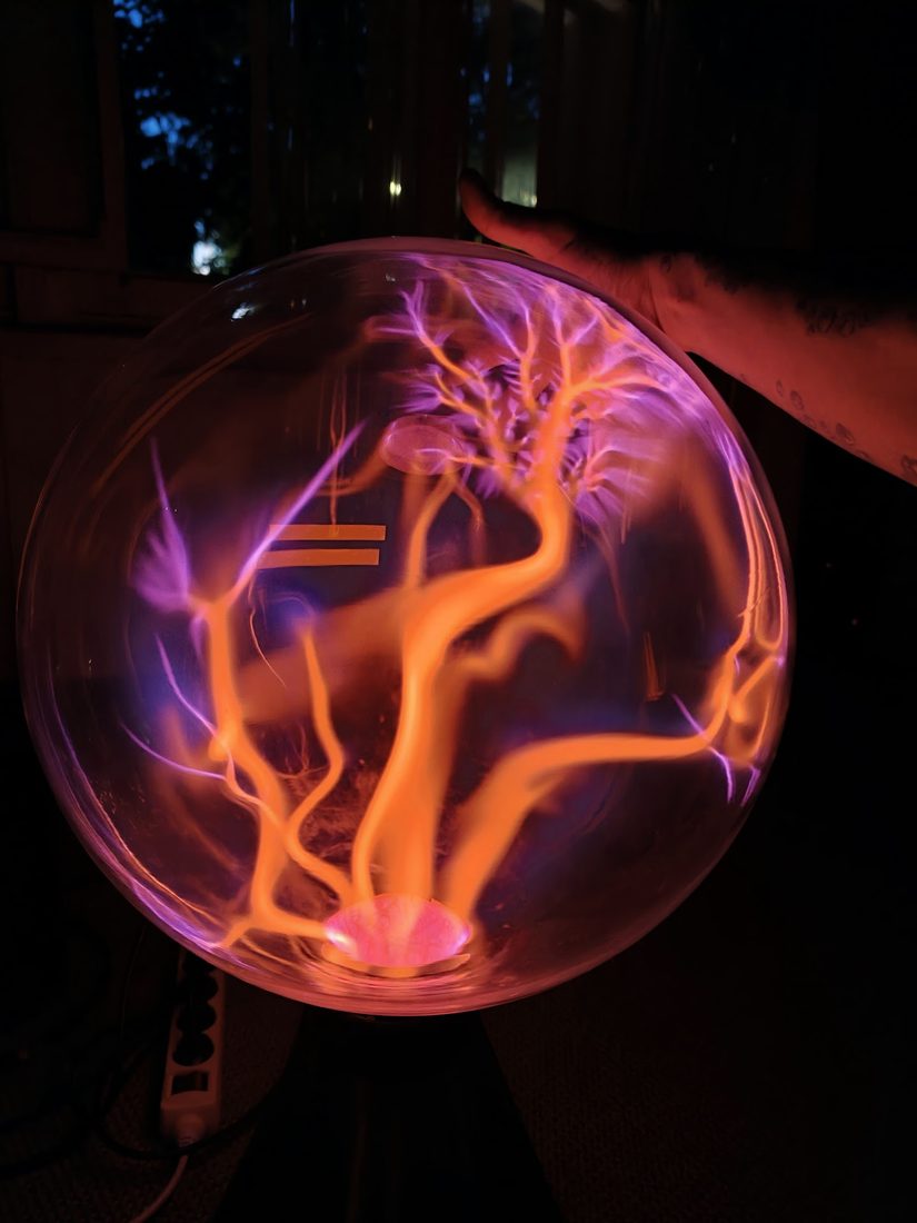 A hand on a plasma sphere, the discharge drawn to the fingertips